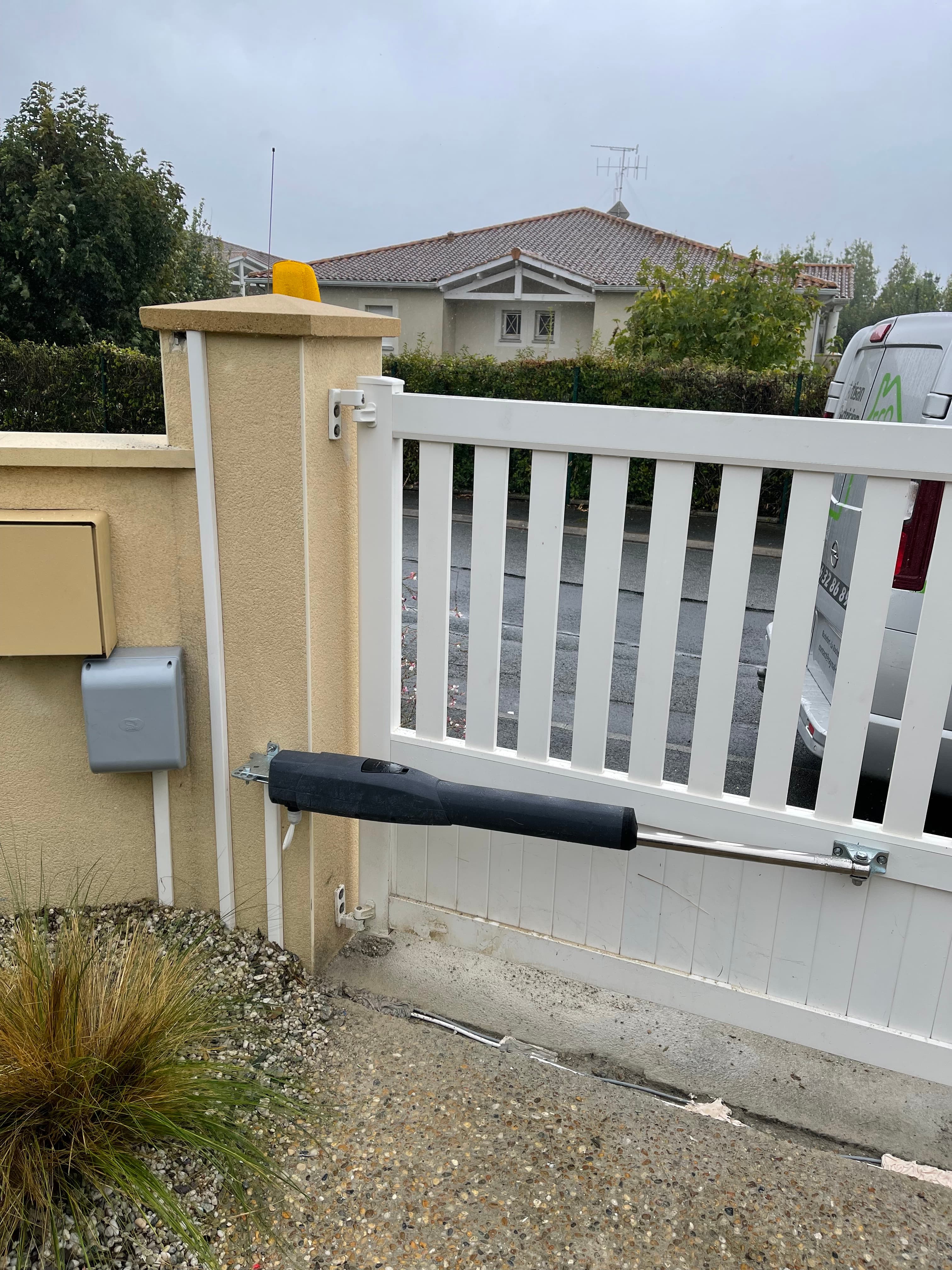 Portail blanc équipé d’une motorisation à bras