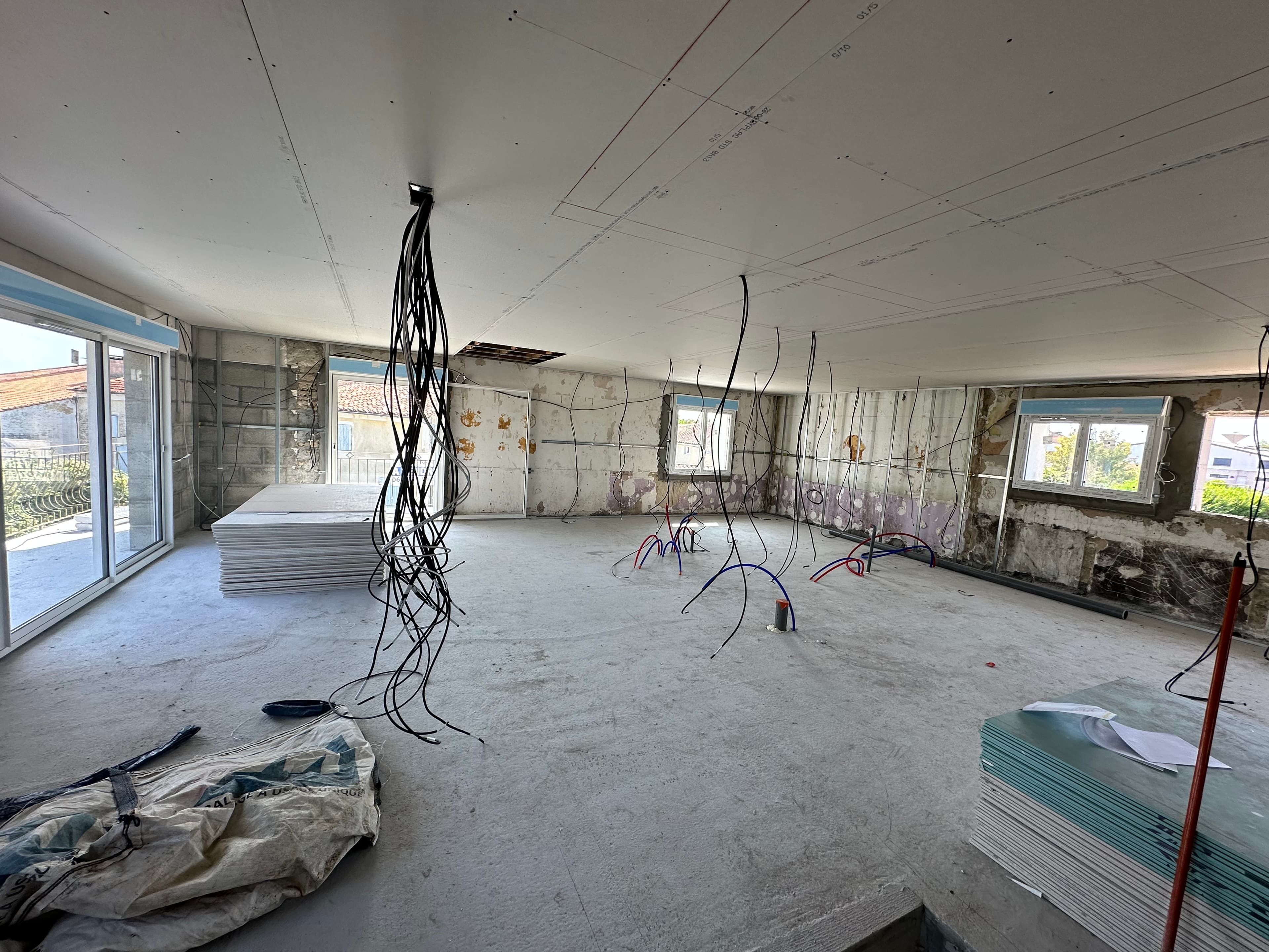 Câbles et gaines en attente dans un intérieur en rénovation
